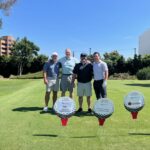 Participants at the Boys & Girls Club of Long Beach "Fore The Kids" golf tournament posing with sponsor signs on the course.